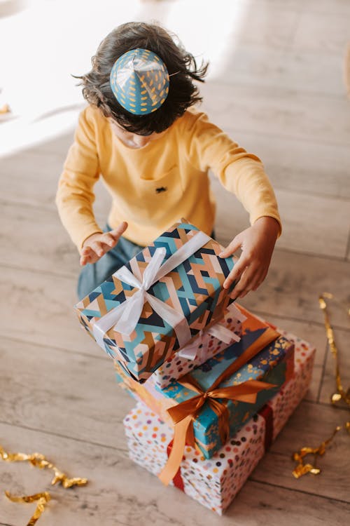 Free Little Boy in Yellow Long Sleeve Shirt Holding Birthday Present Stock Photo