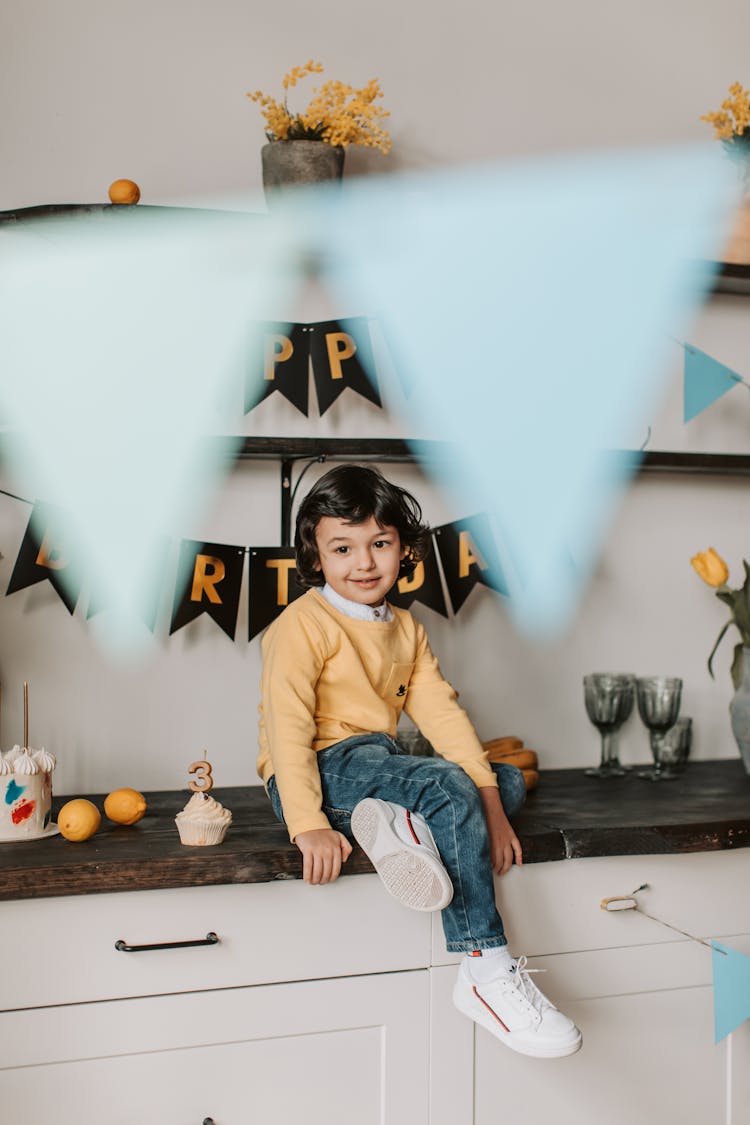 A Boy Sitting On A Kitchen Counter