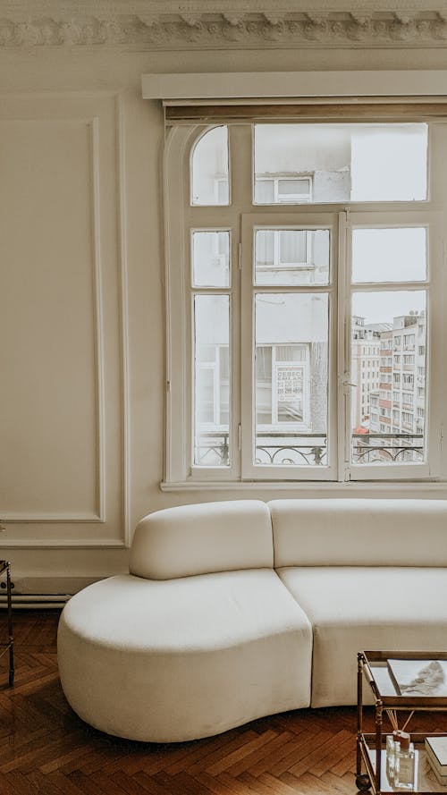 White Leather Couch Beside White Wooden Framed Glass Window