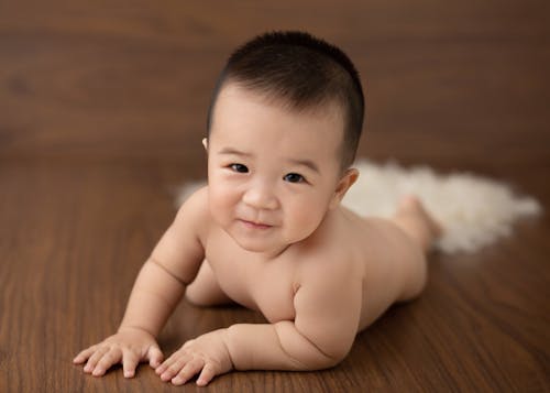 Smiling ethnic toddler on floor in studio