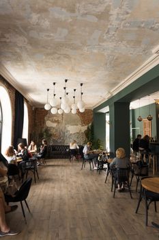 Cozy rustic café interior with customers enjoying their time, featuring vintage decor and ample seating area.