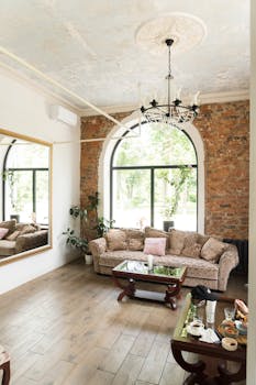 Stylish living room featuring a cozy sofa, elegant chandelier, and large windows for natural light.