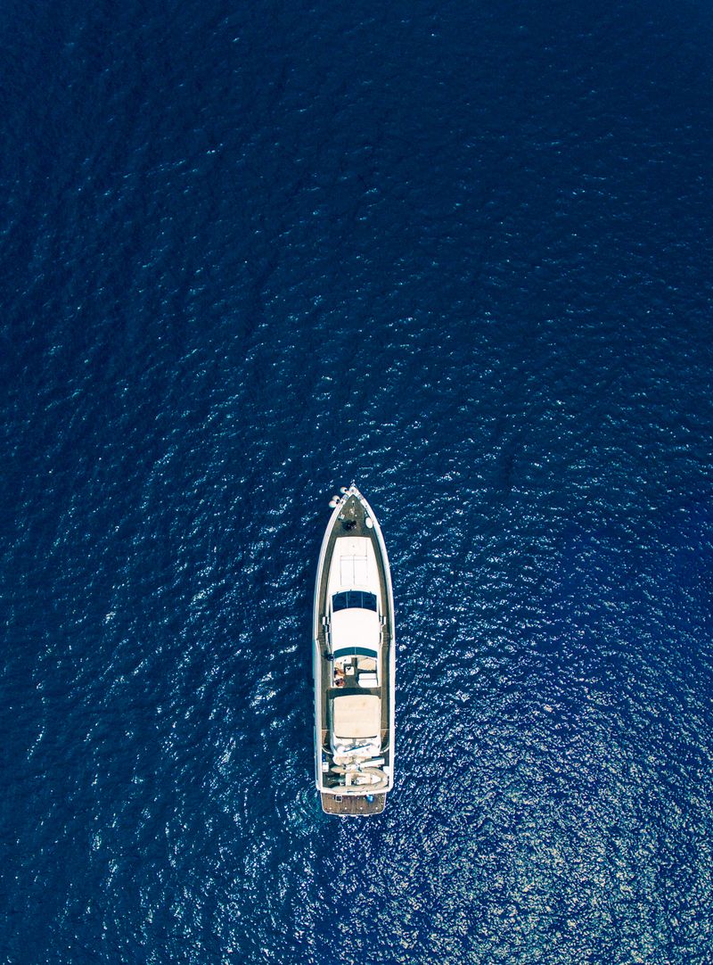 Drone shot of yacht on blue sea with open water