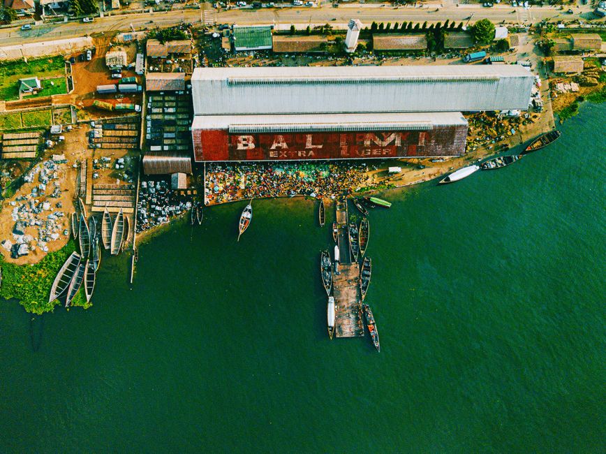 Stunning Victoria Falls : Scenic Day Tour, Lunch & Helicopter Flight Review Review 2026 - Aerial shot of a bustling port along Lake Victoria in Mwanza, Tanzania, with boats and warehouses.