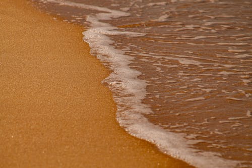 Brown Sand Near Body of Water