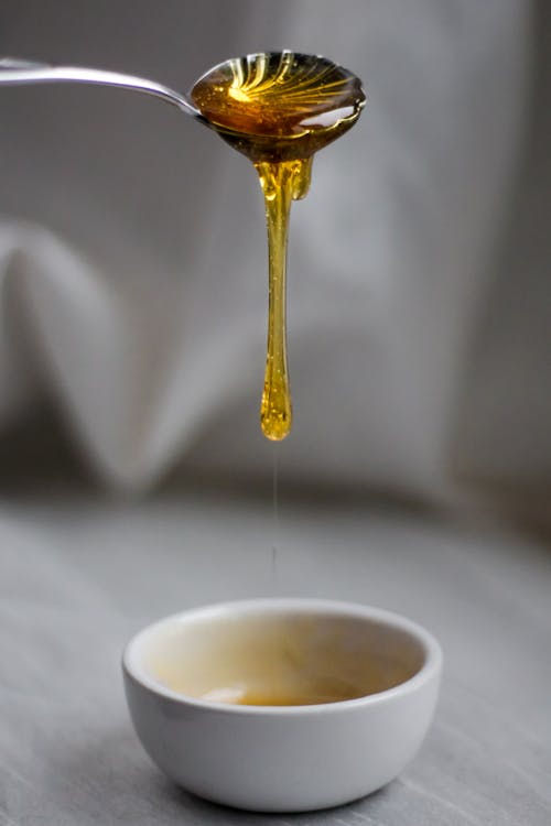 Free Honey Dripping in White Ceramic Bowl Stock Photo