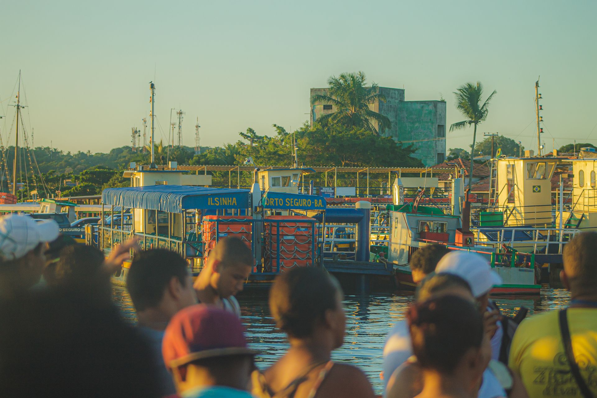 A crowd gathers at the bustling Porto Seguro pier in Bahia, Brazil during daytime.