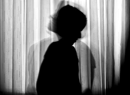 Free Silhouette of Person Standing Near Window Curtain Stock Photo