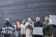 Group of People Standing Near Gray Wall