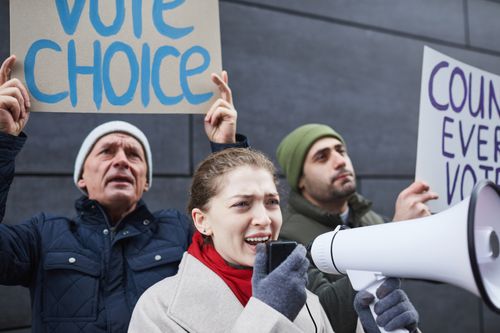 Free Protestors speaking out with signs and megaphone advocating for voting rights. Stock Photo
