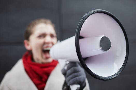 Woman passionately using a megaphone during a protest, emphasizing activism and communication.