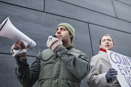 Free A Man Using a Megaphone while Protesting on the Street Stock Photo