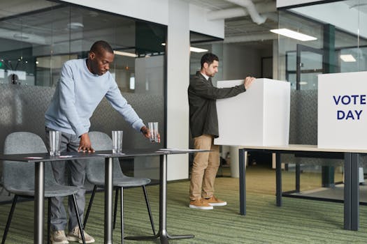 Two men preparing a conference room setup for Vote Day in an office.