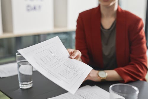 Free A Woman in Red Blazer Holding a Paper Stock Photo
