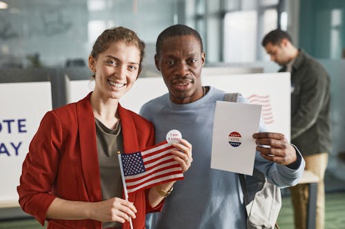 Free Man and Woman Holding Flag and Paper Stock Photo