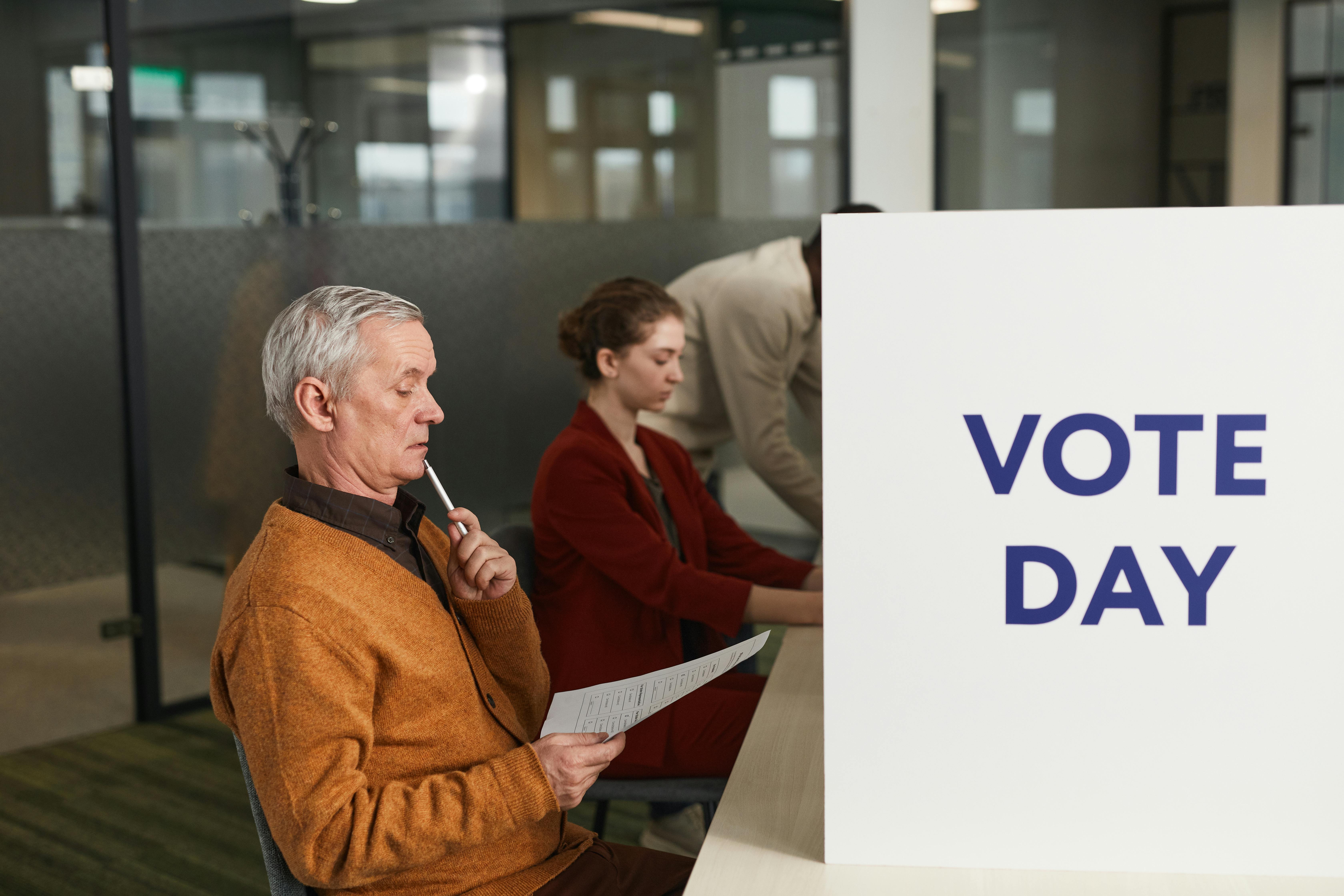 People voting indoors on election day, making decisions at a polling station.