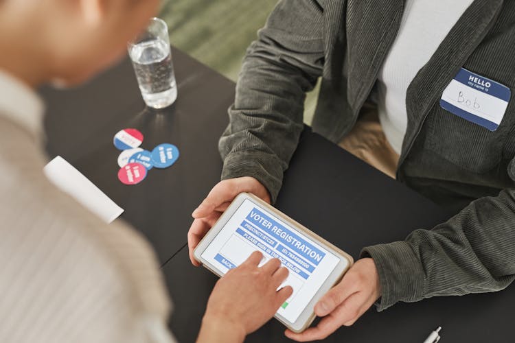 People Using A Tablet While Doing Voter's Registration