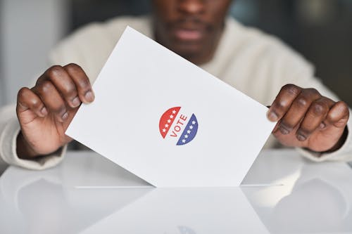 Free Person Putting a Paper in White Ballot Box Stock Photo