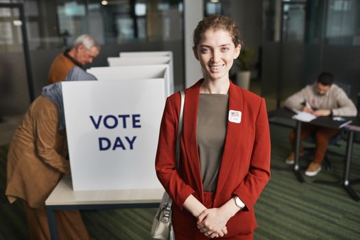 Woman in Red Blazer Standing Inside a Polling Place