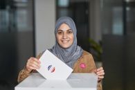 A Woman in Hijab Casting Her Vote