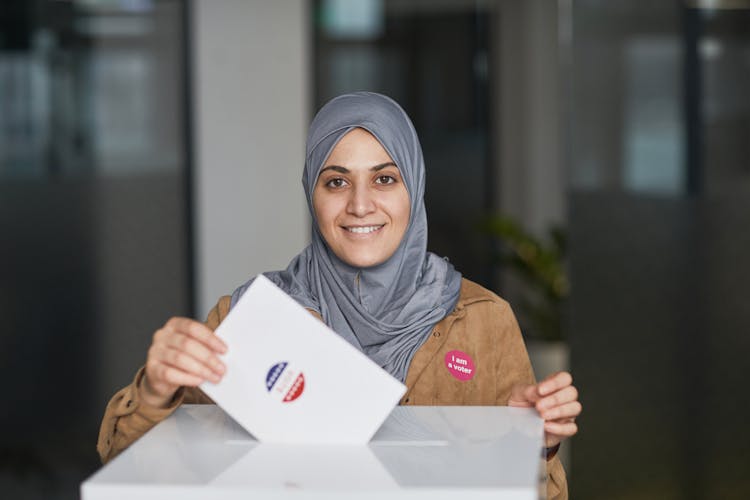 A Woman In Hijab Casting Her Vote