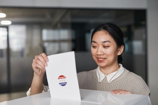 Woman Putting a Ballot in White Box