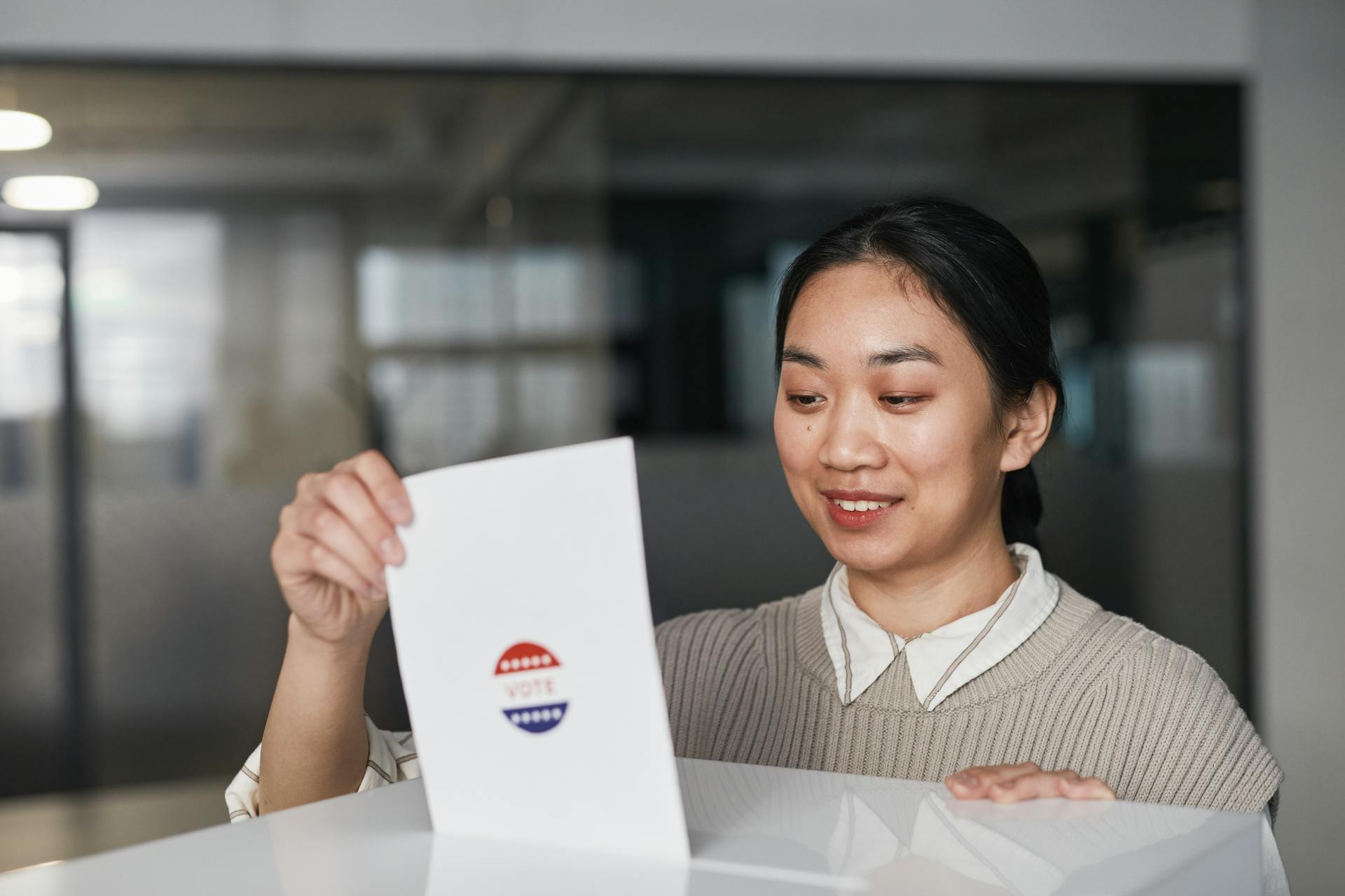 Woman Putting a Ballot in White Box