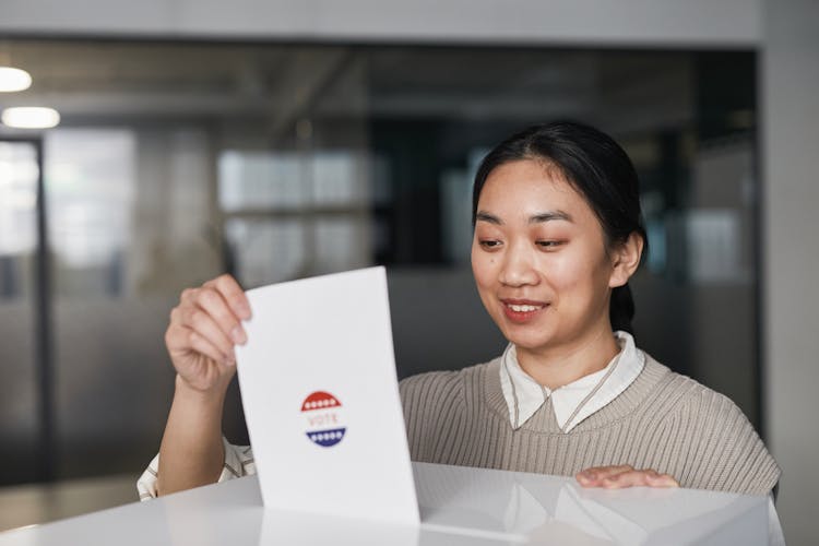 Woman Putting A Ballot In White Box