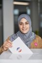 A Woman Wearing Hijab Casting her Vote