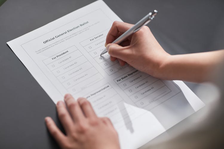 A Peron Filling Up A Voting Ballot