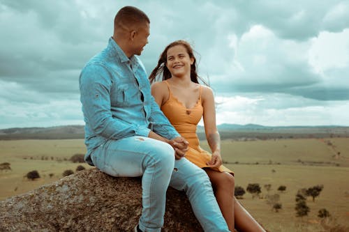 A Romantic Couple Sitting on the Rock while Talking