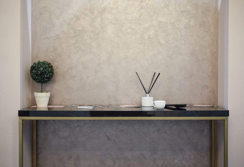 Stylish minimalist interior featuring a modern console table with incense sticks and a small potted plant.
