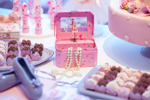 Delightful ballerina-themed birthday setup with pink cake, chocolate treats, and decorative jewelry box.