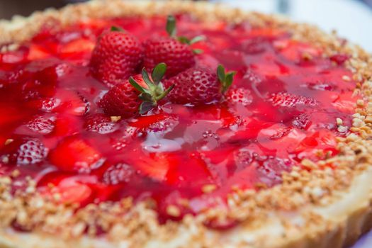 Close-up of a delicious cheesecake topped with fresh strawberries and jelly glaze.