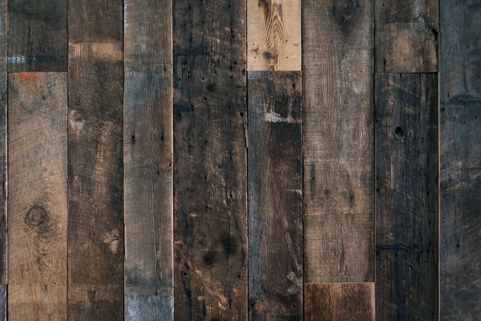 A rustic wooden plank wall with a dark vintage texture, ideal for backgrounds or designs.