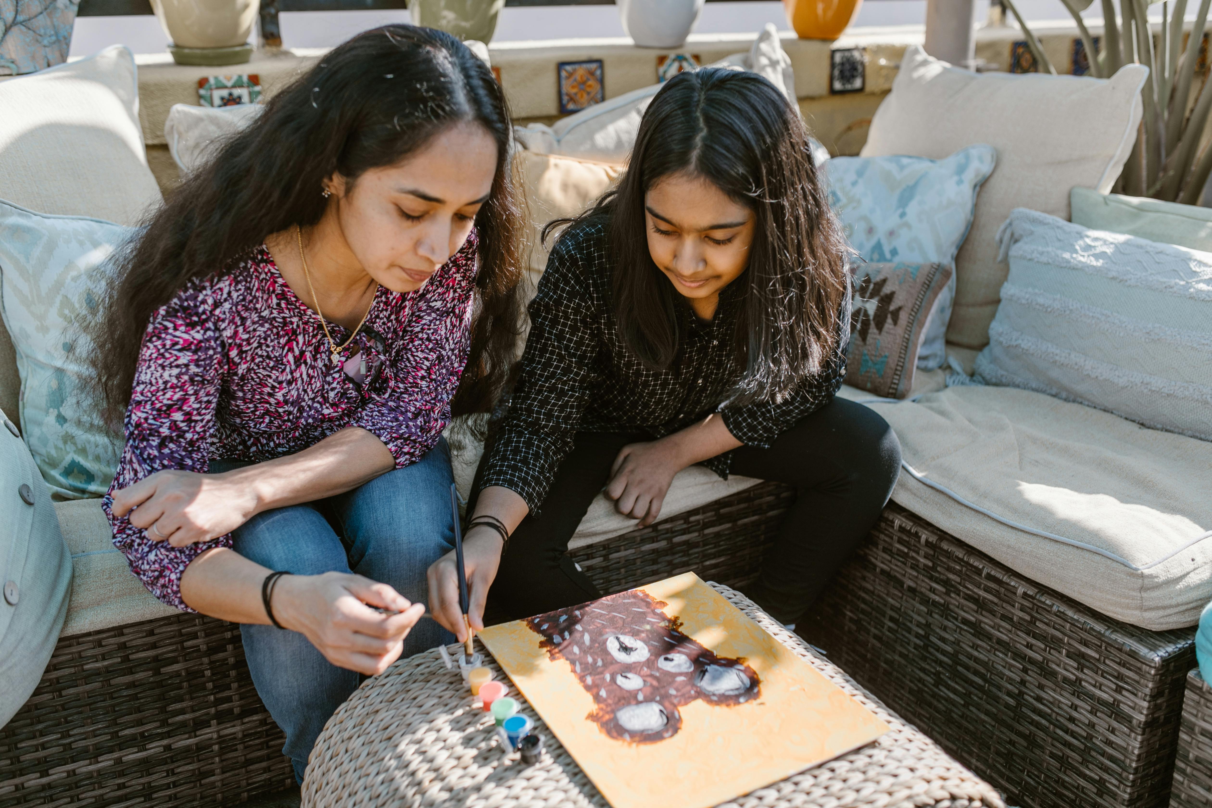 a woman and girl painting together