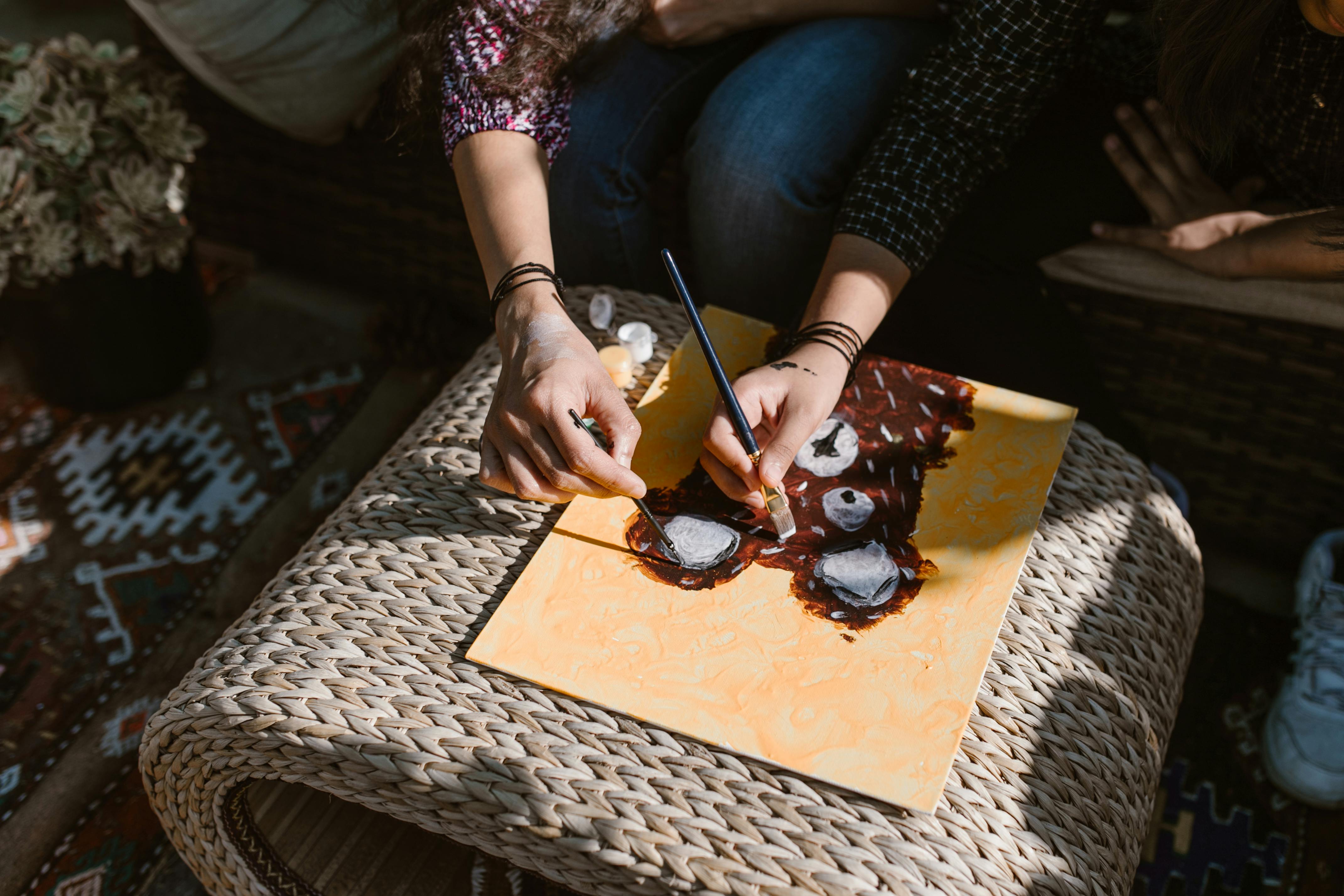 person holding black pen and brown chocolate cake