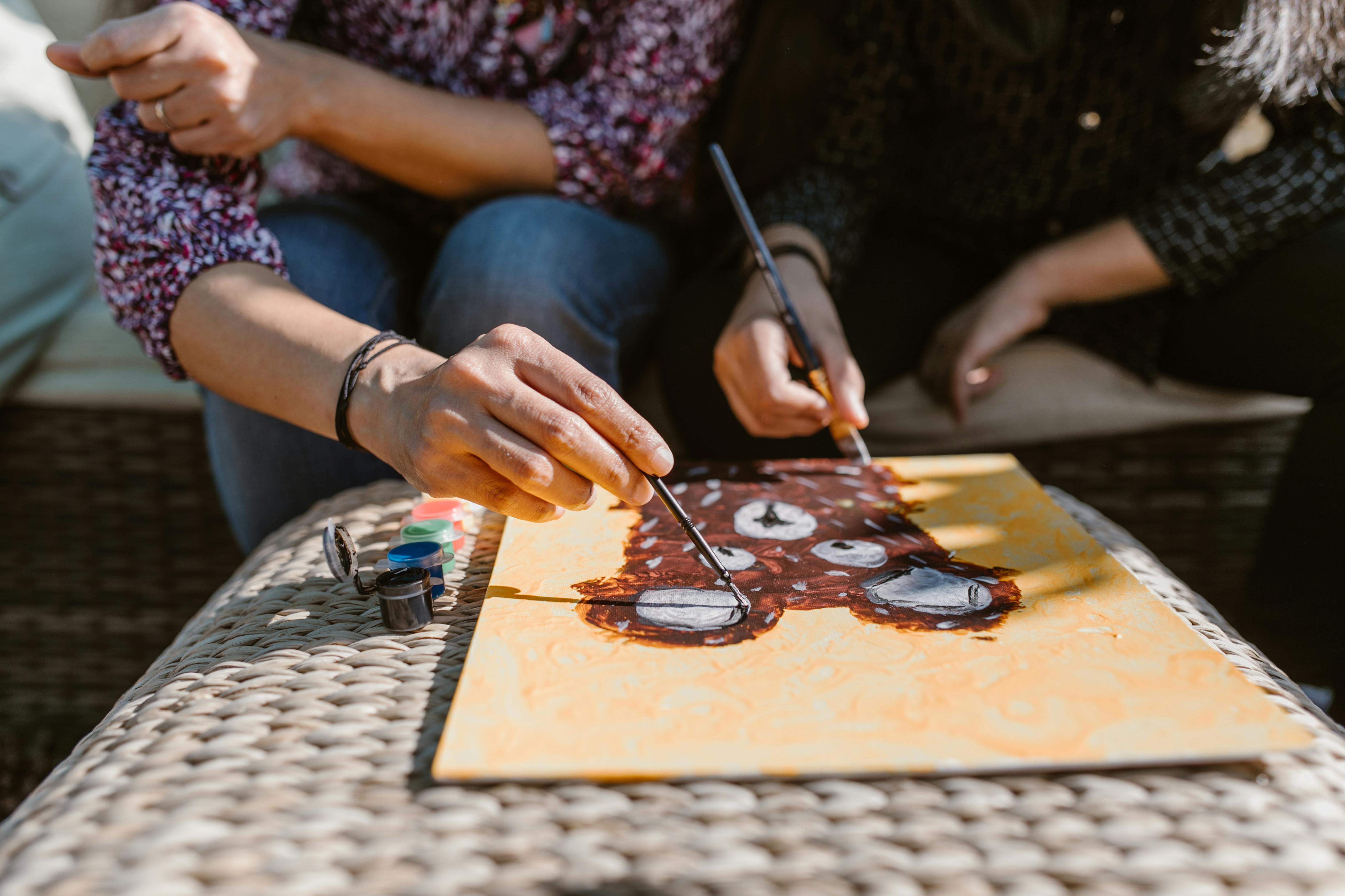 person holding black pen and brown wooden chopping board