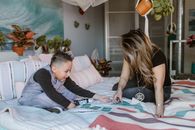 Young mother with preteen son playing cards on bed