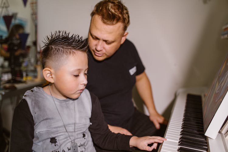 Man In Black Crew Neck Shirt Playing Piano With His Son