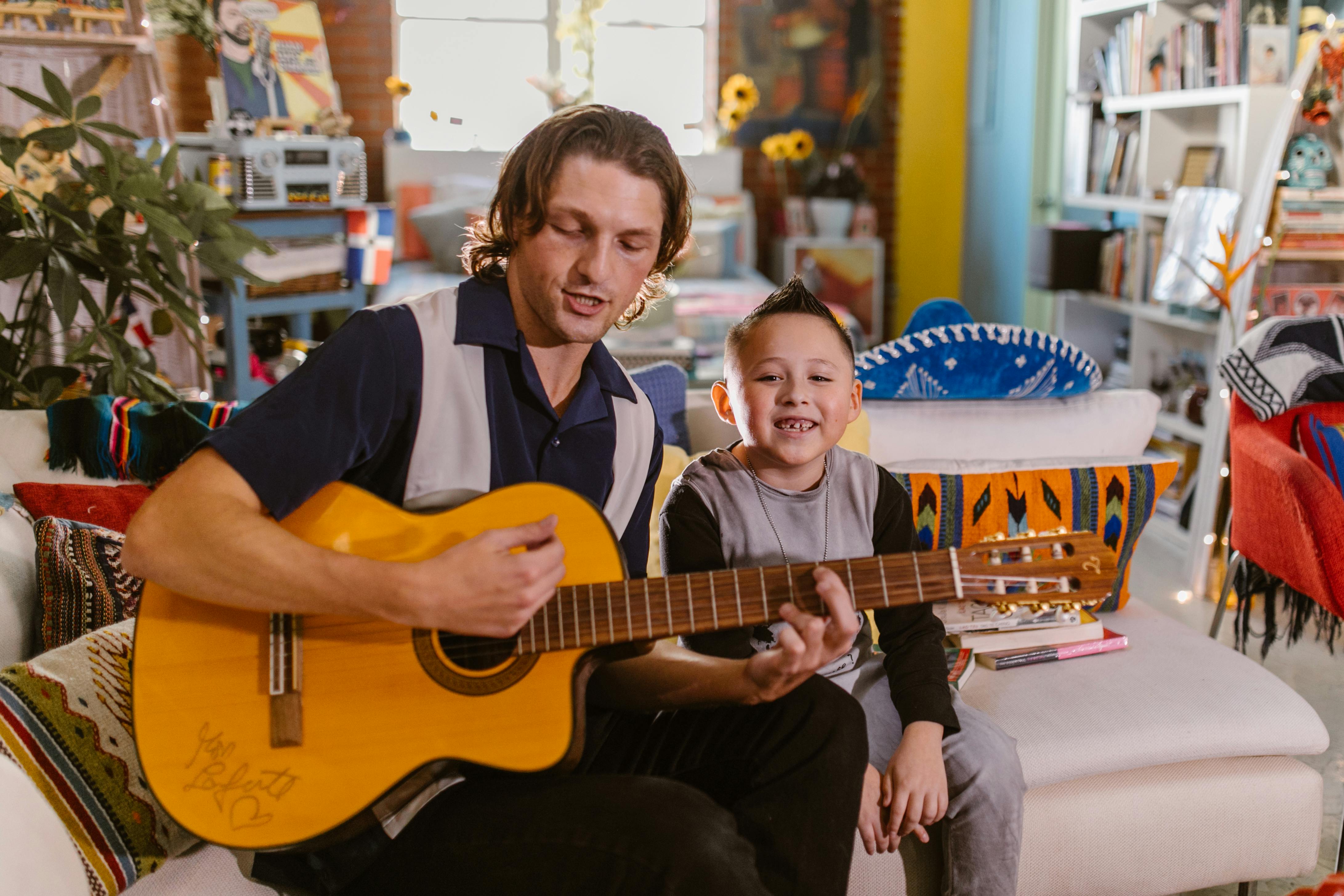 man in black polo shirt playing guitar beside woman in black dress