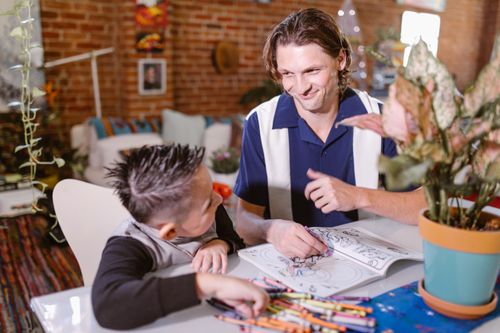 Free Father and son enjoying creative drawing time at home, fostering bonding and early childhood education. Stock Photo
