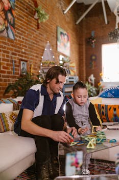 Father and son playing with magnetic blocks indoors, fostering creativity and bonding.