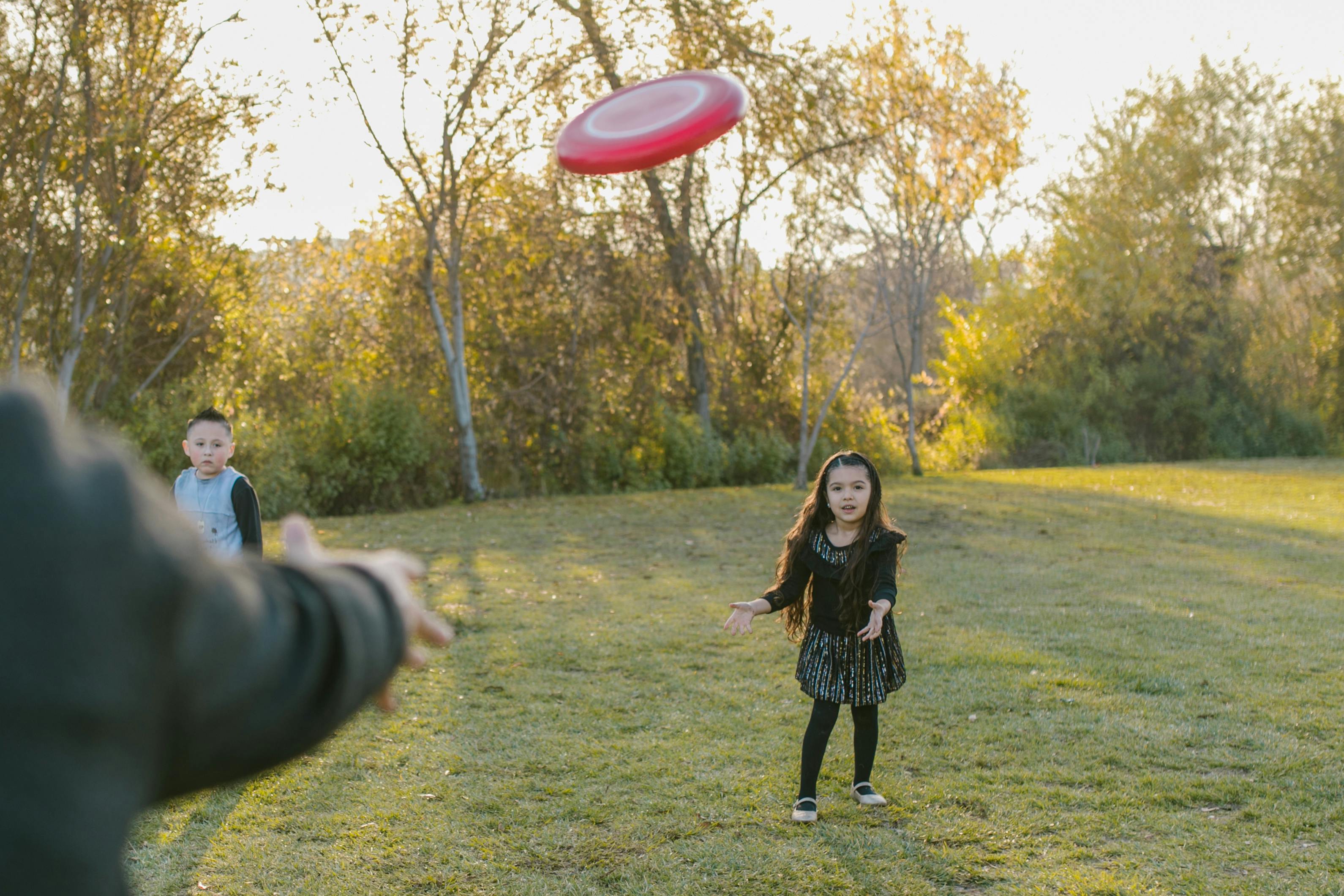 Free Girl in Black Dress Catching Flying Disc Stock Photo