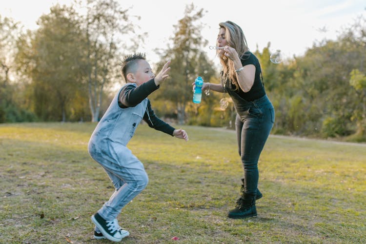 Woman And A Boy Playing Bubbles 