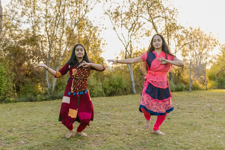 Women Dancing On A Grassy Field