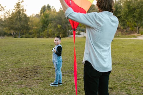 A Person in White Long Sleeves Holding a Kite