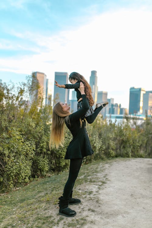 Free A Woman Holding her Daughter in the Air at a Park Stock Photo
