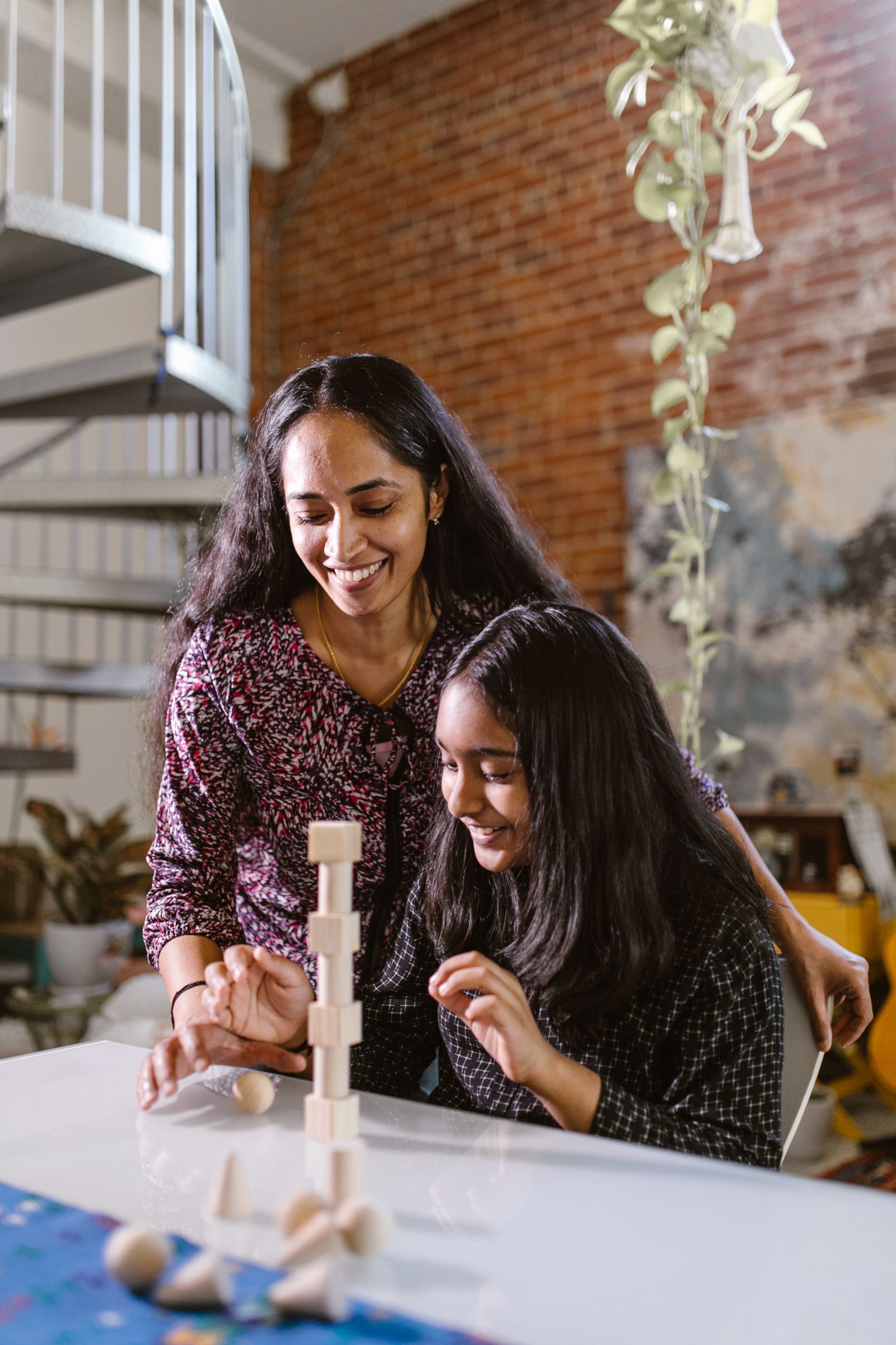 Mother and child creating a neighborhood with colorful wooden building blocks