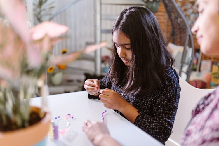 A Girl Making A Bead Bracelet